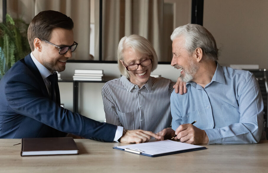 An elderly couple having a meeting with an estate agent