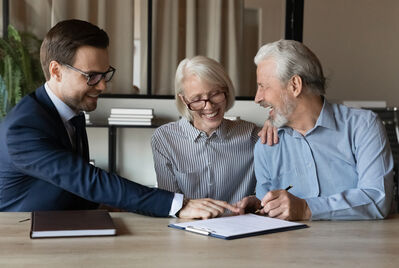 An elderly couple having a meeting with an estate agent