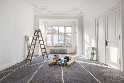 Ladder and paint in the middle of a renovated room