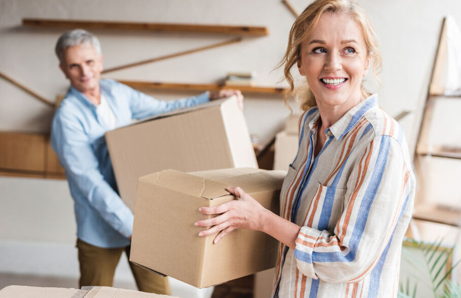 Two people carrying cardboard boxes