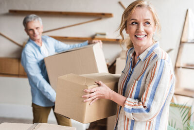 Two people carrying cardboard boxes