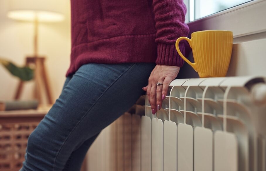 A person's hands on a radiator