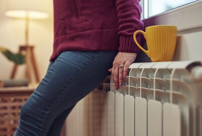 A person's hands on a radiator