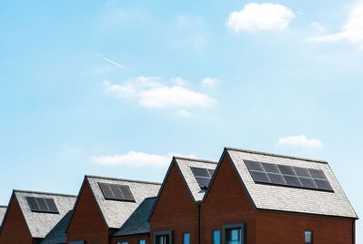 The rooves of houses with solar panels on