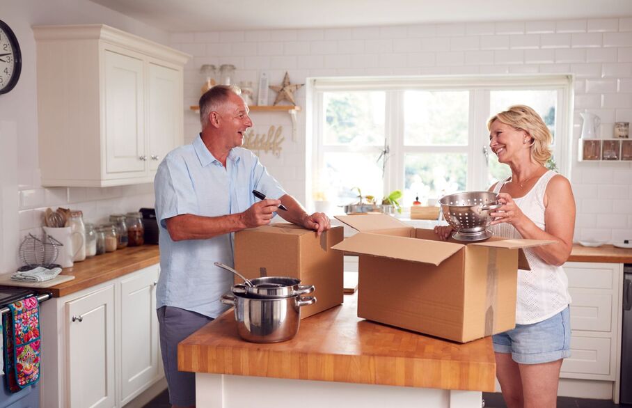 A couple packing up a cardboard box
