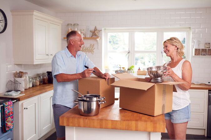 A couple packing up a cardboard box
