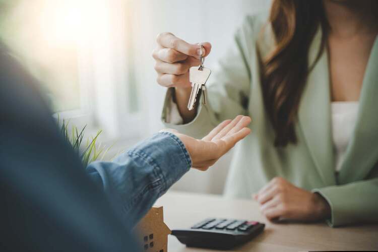 Two people exchanging a set of house keys