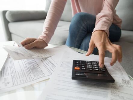 A woman using a calculator and looking at papers