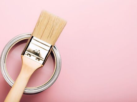 Paintbrush on a tin of pink paint