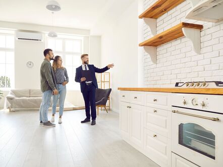 A couple being shown around a house